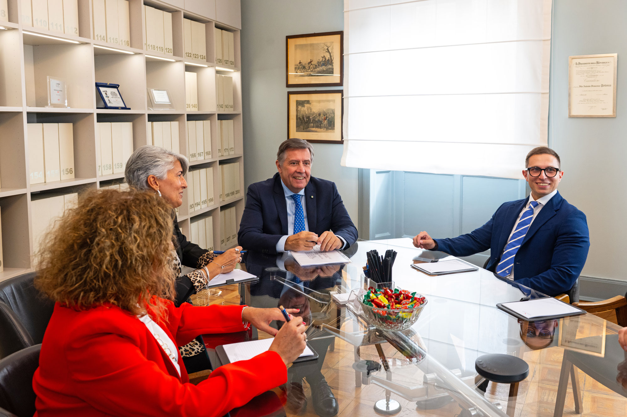 Professionisti dello Studio PMP durante una riunione, con l'archivio della sede alle spalle
