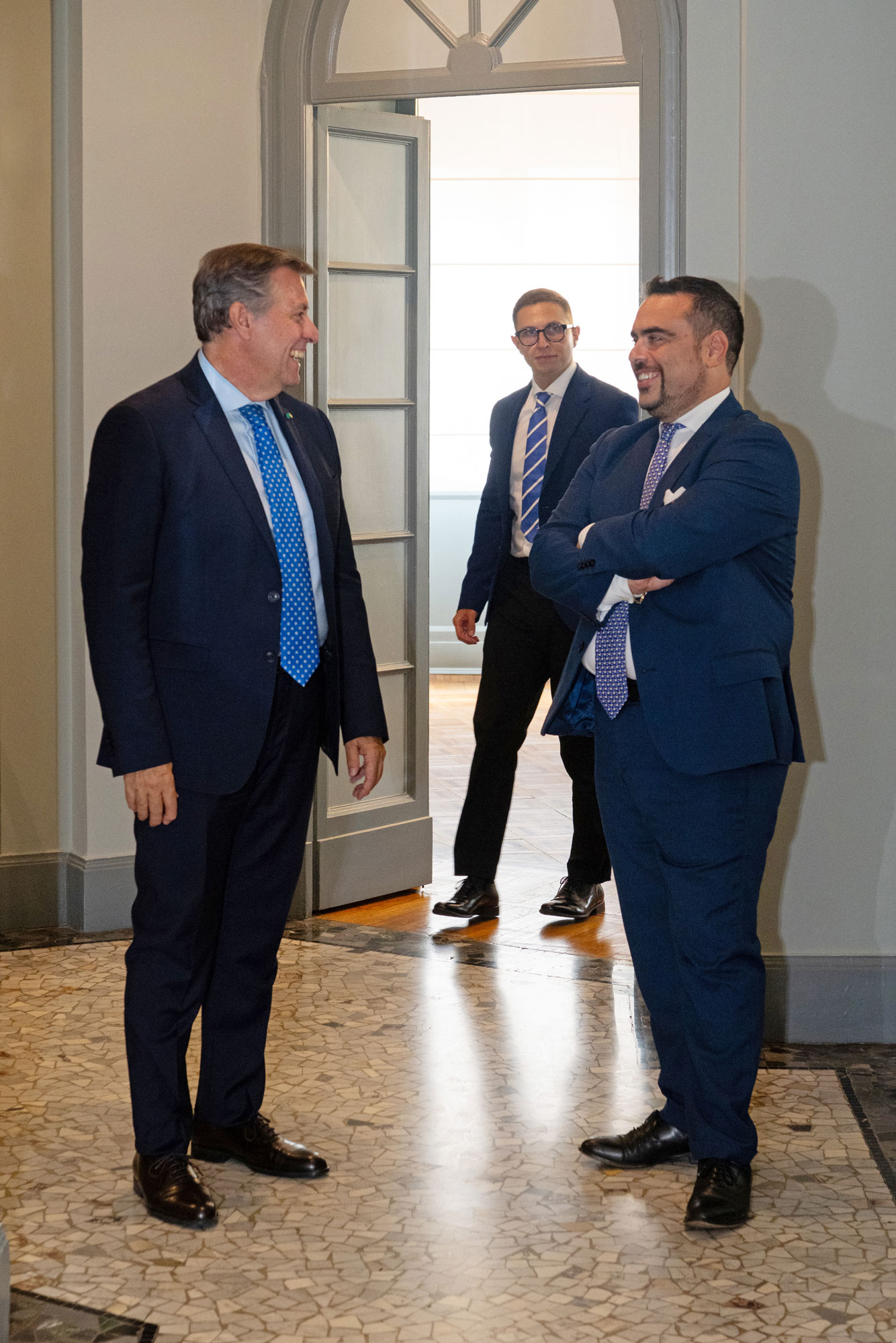 Three PMP professionals in the corridor of the Via Fontana office in Milan